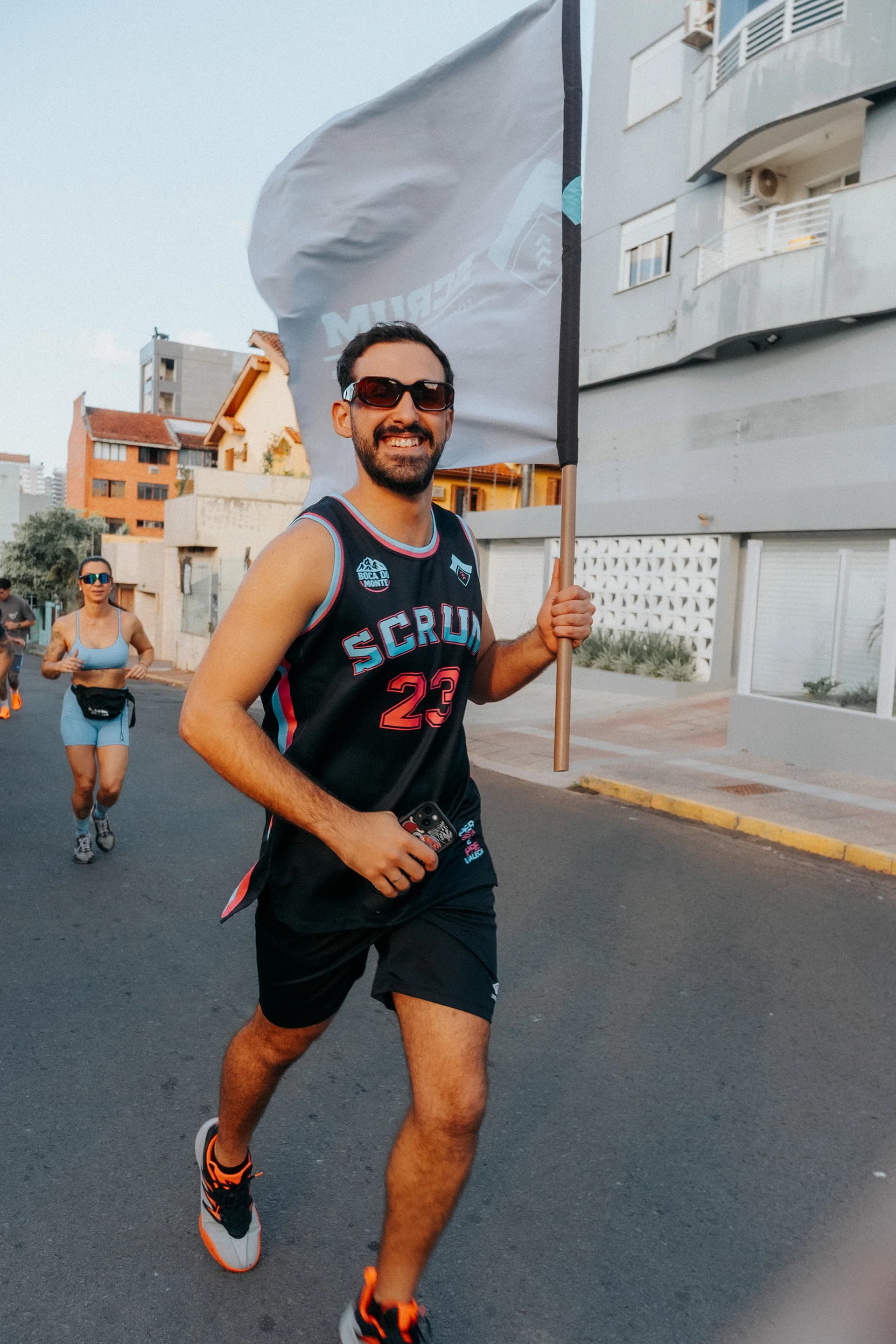 Atleta da Scrum participando de corrida com a bandeira da equipe